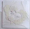 Esküvői meghívó - 150x150 mm - oldalra nyitható - dombornyomott, formastancolt - elejére átlátszó anyagra készült fehér thermoporral díszített szív helyezhető, mely a formastancolásba illeszkedik