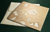 Esküvői meghívó - 150x150 mm - oldalra nyitható - fehér dombornyomású, aranyozott borítóval - a kivágásnál monogram olvasható