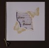      Esküvői meghívó - 140x140 mm - oldalra nyitható - fehér borító, krém színű dombornyomással, ablakos kivágással - pausz betétlappal - arany gumiszalaggal